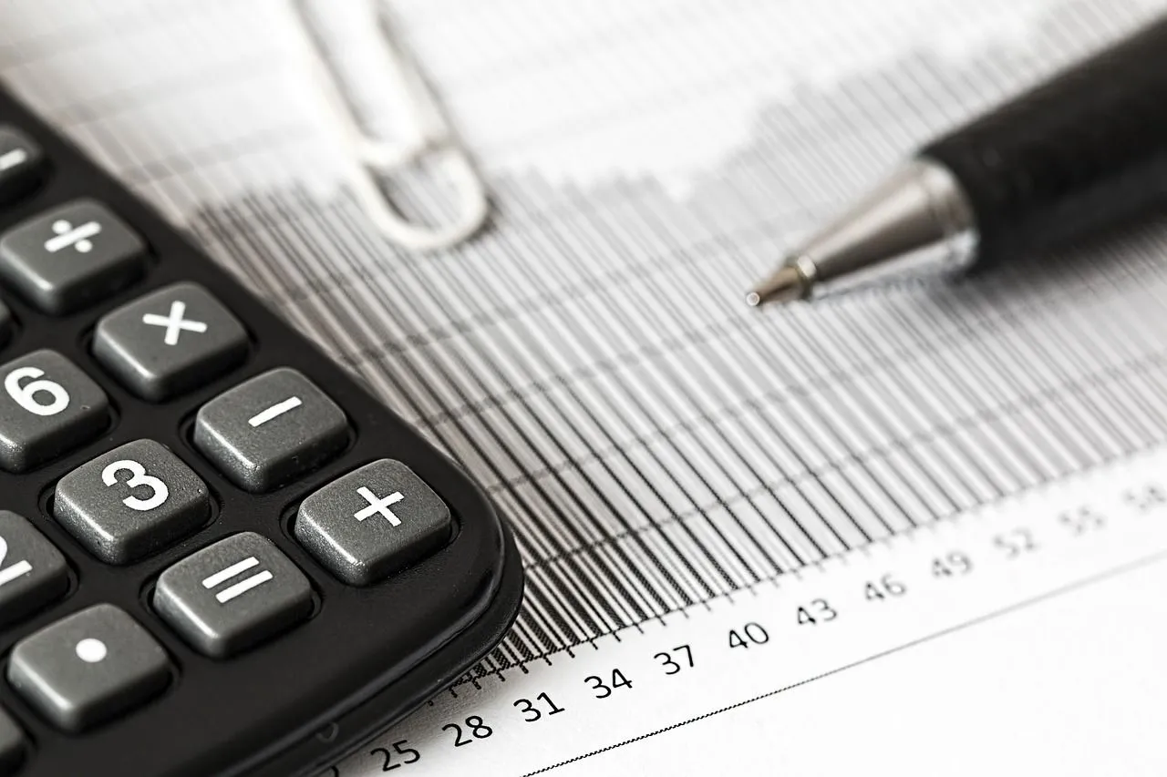 Calculatrice posée sur des documents pour vérifier les cotisations sociales d’un bulletin de paie